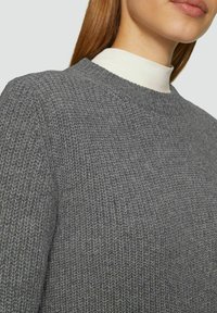 Grauer gestrickter Pullover mit Rundhalsausschnitt, der ein strukturiertes Muster und Rippdetails am Halsausschnitt aufweist. Weicher, mittelschwerer Stoff.