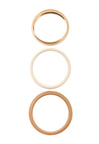 Trzy pierścienie ułożone pionowo: złota metalowa obrączka, gładka kremowa obrączka oraz brązowy skórzany pierścień z przeszyciami.