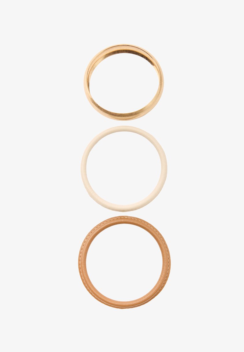 Trzy pierścienie ułożone pionowo: złota metalowa obrączka, gładka kremowa obrączka oraz brązowy skórzany pierścień z przeszyciami.