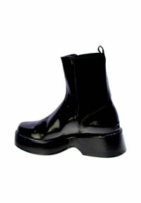 Stivale Chelsea nero lucido con suola spessa, pannelli laterali elastici e linguetta posteriore, mostrato di profilo su sfondo bianco.