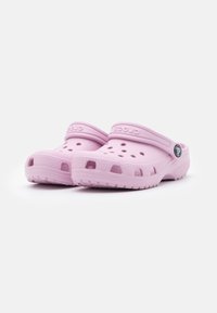 Pink resin clogs with ventilation holes and a back strap, featuring a textured sole and a circular logo accent on the side.