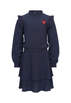 Marineblauwe jurk met een gestructureerde afwerking, rimpelige schouderaccenten, een hoge hals en een gelaagde rok. Heeft een rode hartpatch op de borst.