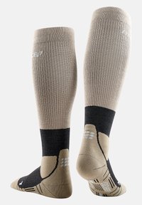 Calze al ginocchio color beige con texture a coste e dettagli neri. Presentano zone imbottite nel tallone e nella punta per comfort e grip.