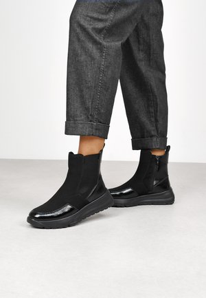 Botines negros con un diseño elegante, que cuentan con un acabado suave y suela de goma. Los acentos texturizados realzan su apariencia moderna.
