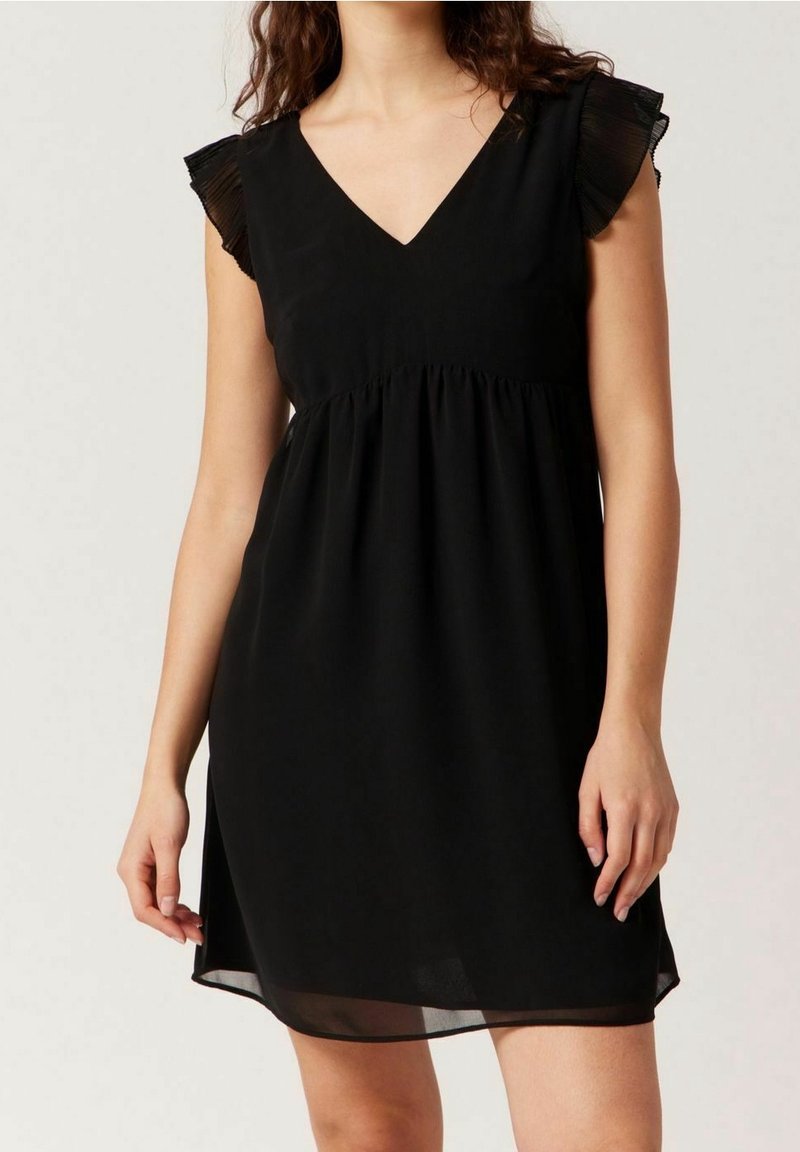 Svart klänning med V-ringning, veckade kappryggar och empiremidja. Tillverkad av lätt material, den har en flödande silhuett.