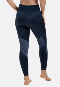 Tummansinisiä legginssejä, joissa on eri sävyisiä kankaita, korkea vyötärö, sileä pinta ja geometrinen paneelimalli.