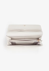 Lichtgrijze portemonnee met meerdere compartimenten, een gladde textuur, goudkleurige hardware en een binnenzak met rits voor veilige opslag.