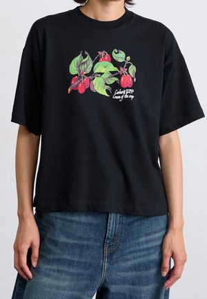 Sort bomulds T-shirt med et farverigt grafik af frugt og blade. Løs pasform med korte ærmer, rund halsudskæring og lige kant.