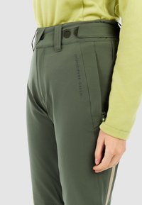 Groene outdoorbroek met een slim fit, gemaakt van rekbaar materiaal. Voorzien van een knoopsluiting en een zijvak met rits met een beige accentstrook.
