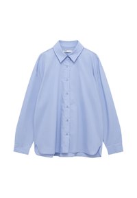 Camicia azzurra oversize a maniche lunghe con bottini, colletto a punta e orlo curvato, esposta su uno sfondo bianco.