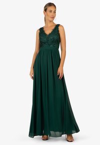 Lang grøn kjole lavet af lagdelt chiffon med en broderet blondetop, der har V-hals og en A-formet silhuet.