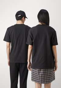 Tommy Jeans VARSITY TEE UNISEX - Camiseta estampada - black