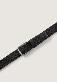 Ceinture tissée noire avec une boucle en métal, présentant un accent en cuir lisse près de la boucle. Tissu texturé et design élastique pour plus de flexibilité.