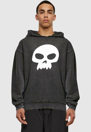 Black hoodie with a large white skull graphic in the center. Featuring a relaxed fit, ribbed cuffs, and a drawstring hood.