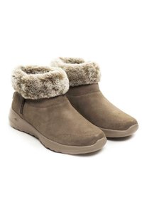 Braune Wildleder-Stiefeletten mit einem Kunstfellbund, runder Spitze und strukturiertem Fußbett. Seitlicher Reißverschluss für einfaches Anziehen. Weiches Innenfutter.