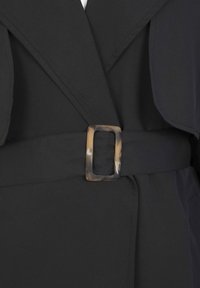 Black garment featuring a wide collar, smooth fabric, and a belt with a rectangular tortoiseshell buckle for fastening.