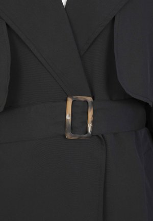 Black garment featuring a wide collar, smooth fabric, and a belt with a rectangular tortoiseshell buckle for fastening.