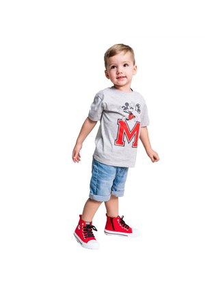 Graues T-Shirt mit kurzen Ärmeln, das ein Mickey Mouse-Design und ein großes rotes "M" zeigt, kombiniert mit hellblauen Jeansshorts und leuchtend roten High-Top-Sneakers.