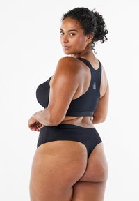 Czarny stanik sportowy z zaokrąglonym dekoltem i szerokimi ramiączkami, w parze z majtkami bikini o wysokim stanie. Gładki materiał, minimalistyczny design.