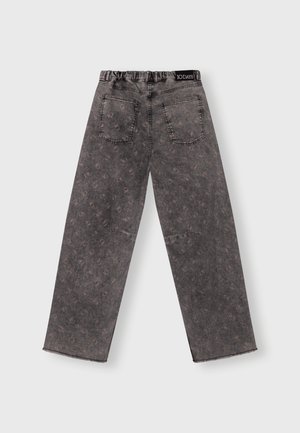 Pantaloni in denim grigio con vestibilità rilassata, caratterizzati da un design a fantasia, cintura elastica e due tasche posteriori. Orlo finito in modo strappato.