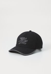 Casquette de baseball en laine noire avec un logo brodé blanc et une couture contrastante blanche le long de la visière et autour de la base.
