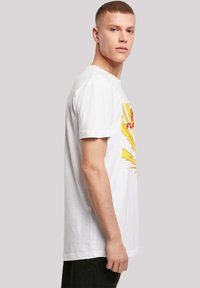 Hvid bomulds T-shirt, korte ærmer, med et gult lyndesign og rød grafiktekst på forsiden. Enkelt rundt halsudskæring.