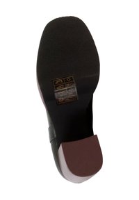 Suola di scarpa in gomma nera con motivo testurizzato per la presa; punta arrotondata, tacco marrone a contrasto e istruzioni per la cura stampate in oro.