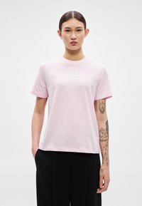 Ροζ βαμβακερό t-shirt με κοντά μανίκια, με λευκό κεντητό λογότυπο "Calvin Klein" στο στήθος. Λείο ύφασμα, άνετη εφαρμογή.