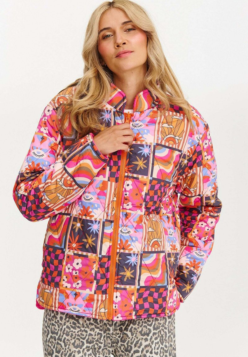 Kurtka pikowana z żywym, wielopatternowym wzorem zawierającym motywy kwiatowe, oczu oraz geometryczne. Pomarańczowy zamek, wysoki kołnierz i kontrastowe mankiety.