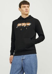 Sudadera negra con un bolsillo tipo canguro en la parte delantera, cordones con acentos en naranja y amarillo, y un diseño de logo impreso en el pecho.