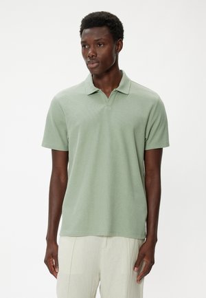 Lys grøn kortærmet polo-shirt med tekstureret stof, klassisk krave og lige kant. Bæres med lyse bukser.