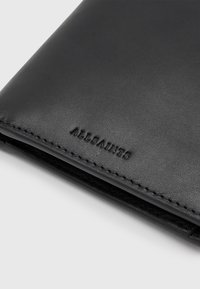 Zwarte leren portemonnee met een gladde textuur, subtiele stiksels en het reliëf "ALLSAINTS" logo aan de voorkant.