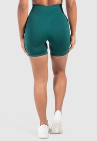 Hoge taille turquoisekleurige shorts van rekbaar materiaal, met een gladde textuur en een aansluitend ontwerp dat de beenlengte accentueert.