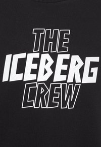 Felpa nera con testo bianco audace che recita "THE ICEBERG CREW". Il testo presenta un design grafico con angoli acuti.