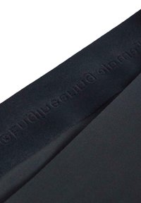 Tessuto nero con una texture liscia, caratterizzato da una vita opaca con un logo inciso delicato. Il design è semplice ed elegante.
