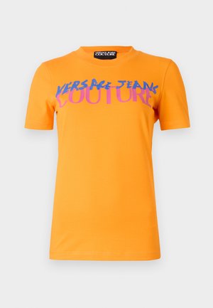 T-shirt en coton orange avec un texte graphique en bleu et rose audacieux "VERSACE JEANS COUTURE" sur le devant. Manches courtes et design à col rond.