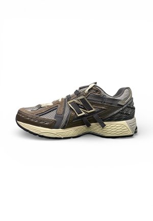 Zapatilla deportiva para hombre de New Balance en tonos marrón, gris y beige, con paneles de malla, superposiciones de ante y suela acolchada, vista lateral.