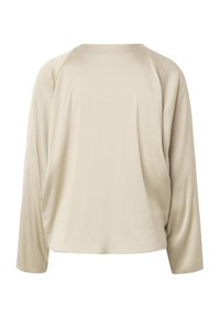 Blouse beige à manches longues avec une coupe ample et des manches raglan, présentée sur un fond blanc.
