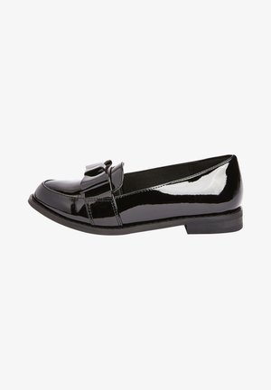 Mocasines de charol negro con punta redondeada, acento de lazo en la parte delantera y un tacón bajo y plano. Textura suave y brillante con detalles de costura.