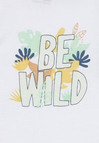 Κείμενο «ΝΑ ΕΙΣΑΙ ΆΓΡΙΟΣ» με πολύχρωμα αφηρημένα φύλλα και φυτικά σχέδια σε πράσινο, κίτρινο, καφέ και σκούρο μπλε σε λευκό φόντο.