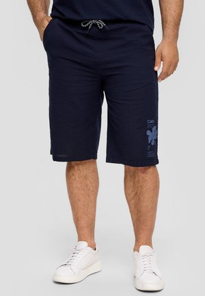 Marineblauwe shorts van een gestructureerde stof, met een elastische tailleband en een trekkoord, en een grafische print op het linkerpijp.