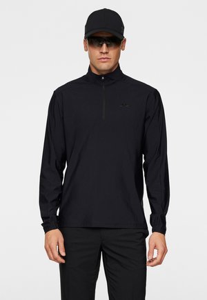Zwarte lange mouwen shirt met een hoge kraag en gedeeltelijke rits, met een reliëflogo op de borst en elastische boorden.