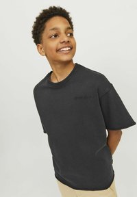 Svart kortärmad t-shirt i bomull, med rund halsringning och subtilt upphöjd "ORIGINALS"-logotyp på bröstet.