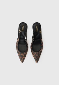 Talons slingback en imprimé léopard avec bouts pointus, contours noirs et accents dorés. Texture lisse avec un design élégant et moderne.