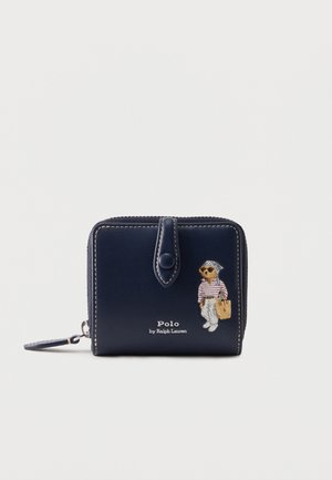 Tengerészkék cipzáras pénztárca pattintós fedéllel, elején napszemüveges medve csíkos ingben, fehér nadrágban és bevásárlótáskával, Polo by Ralph Lauren márkajelzéssel.