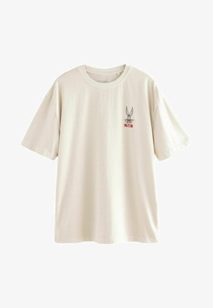 Kreemikaalane puuvillane T-särk, millel on lühikesed varrukad ja ümmargune kaelus. Eriti silmapaistev graafika koomilisest jänesest rinnal.