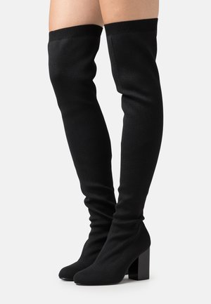 Sorte over-the-knee-støvler lavet af blødt stof med ribbet overdel, med en chunky blokhæl og et slankt tådesign.