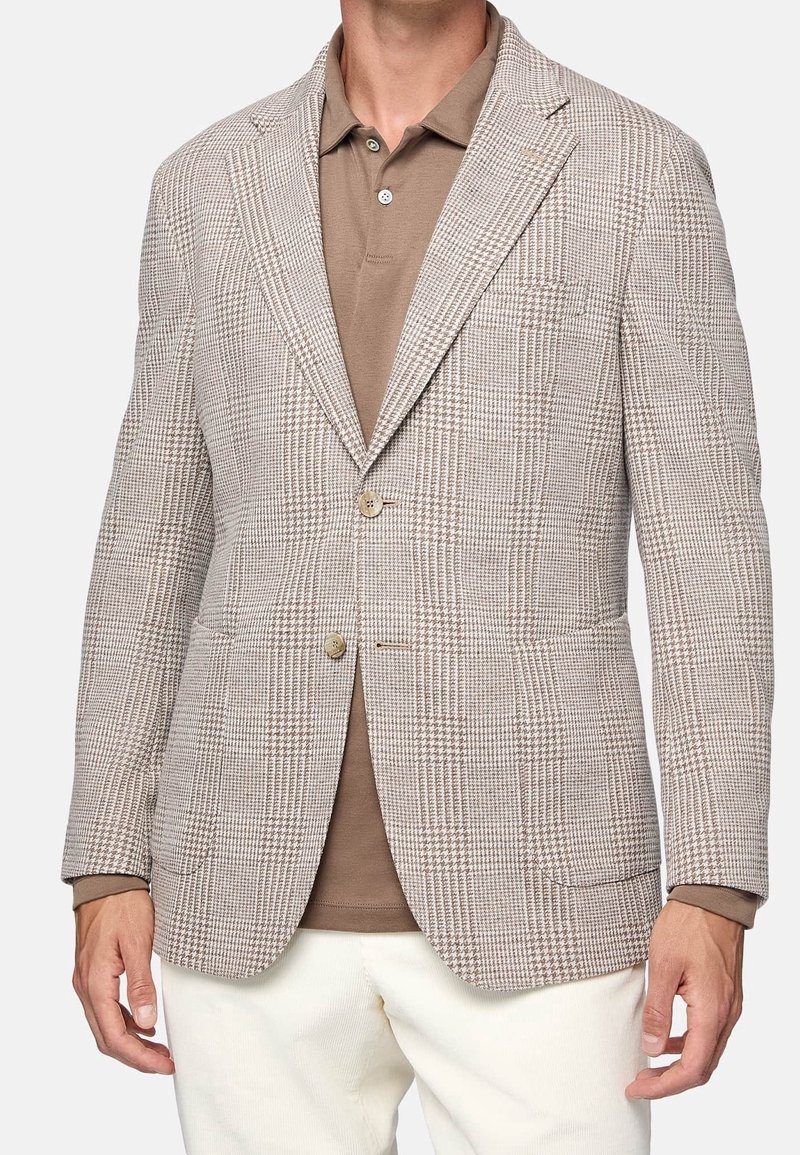 Ljusbrun rutig kavaj i strukturerad tyg, med två knappar, utsvängda slag och två framfickor, tillsammans med en brun polo-tröja.