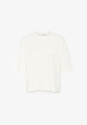 White cotton t-shirt with short sleeves, round neck, and a textured logo patch on the left chest, featuring a boxy silhouette.