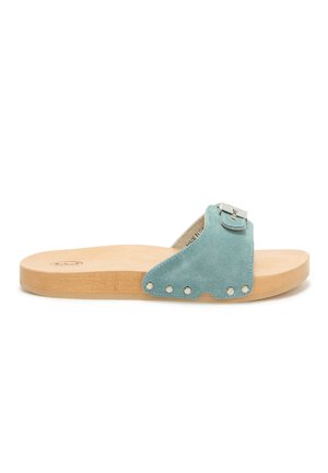 Slip-on sandal med lys træsål og teal ruskindsrem med sølvspænde og nitte detaljer.